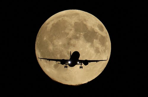A passenger plane passes in front of the first supermoon of the year, known as the Harvest Moon, as it flies above London, Britain, October 6, 2025. REUTERS/Toby Melville TPX IMAGES OF THE DAY
