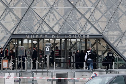 Forensic police officers arrive at the Louvre museum after reports of a robbery