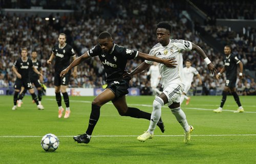 Soccer Football - UEFA Champions League - Real Madrid v Juventus - Santiago Bernabeu, Madrid, Spain - October 22, 2025 Juventus' Pierre Kalulu in action with Real Madrid's Vinicius Junior REUTERS/Susana Vera