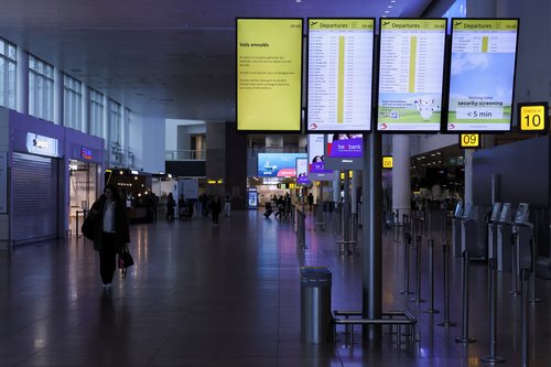 A passenger walks near a board displaying information on cancelled flights, during a nationwide strike against the government's reform plans, at Brussels Airport in Zaventem near Brussels, Belgium October 14, 2025. REUTERS/Omar Havana