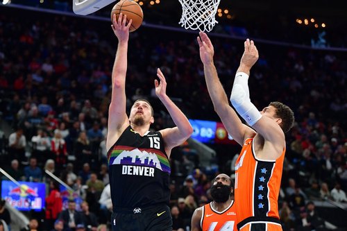 Nov 12, 2025; Inglewood, California, USA; Denver Nuggets center Nikola Jokic (15) moves to the basket against Los Angeles Clippers center Brook Lopez (11) during the second half at Intuit Dome. Mandatory Credit: Gary A. Vasquez-Imagn Images
