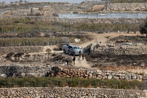 Israeli settlers gather as Palestinians protest against them taking over their land, near Hebron in the Israeli-occupied West Bank, November 13, 2025. REUTERS/Mussa Qawasma