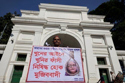 A man holds a poster demanding the capital punishment ahead of the verdict on charges of crimes against humanity against the ousted PM Sheikh Hasina, in Dhaka, Bangladesh, November 17, 2025. REUTERS/Mohammad Ponir Hossain TPX IMAGES OF THE DAY