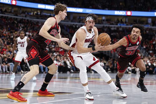 Nov 21, 2025; Chicago, Illinois, USA; Chicago Bulls forward Matas Buzelis (14) and guard Tre Jones (30) defend against Miami Heat forward Jaime Jaquez Jr. (11) during the second half at United Center. Mandatory Credit: Kamil Krzaczynski-Imagn Images