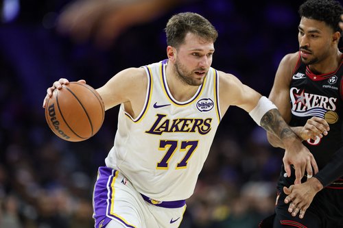 Dec 7, 2025; Philadelphia, Pennsylvania, USA; Los Angeles Lakers guard Luka Doncic (77) drives against Philadelphia 76ers guard Quentin Grimes (5) during the second quarter at Xfinity Mobile Arena. Mandatory Credit: Bill Streicher-Imagn Images