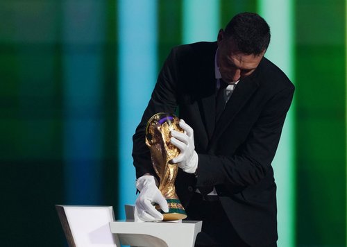 Soccer Football - FIFA World Cup 2026 - FIFA World Cup 2026 Draw - John F. Kennedy Center for the Performing Arts, Washington, D.C., U.S. - December 5, 2025 Argentina coach Lionel Scaloni brings the World Cup trophy onto stage during the FIFA World Cup 20