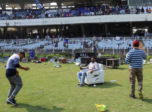 A fan poses for a picture while sitting on a damaged sofa after Argentine soccer star Lionel Messi left the Vivekananda Yuva Bharati Krirangan stadium during his India tour, Kolkata, India, December 13, 2025. REUTERS/Sahiba Chawdhary