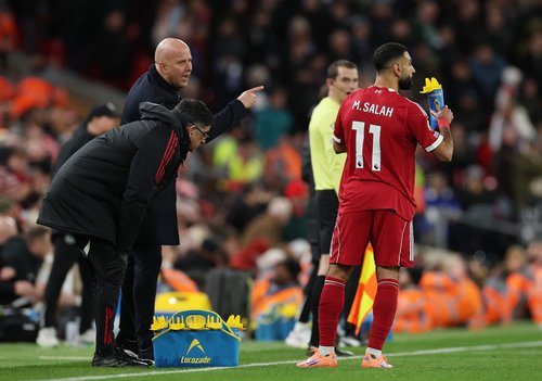 Soccer Football - Premier League - Liverpool v Brighton & Hove Albion - Anfield, Liverpool, Britain - December 13, 2025 Liverpool's Mohamed Salah during a break in play as manager Arne Slot looks on REUTERS/Phil Noble EDITORIAL USE ONLY. NO USE WITH UNAUT