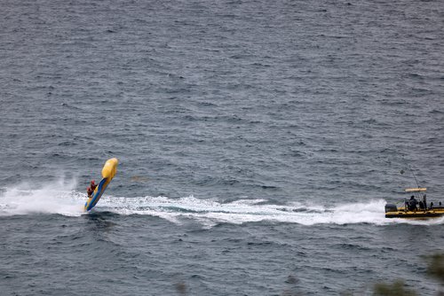 Tourists ride a flat rubber boat which is pulled by a speed boat as they enjoy the sun at the Mediterranean Sea in Lloret de Mar, Spain July 11, 2025. REUTERS/Nacho Doce