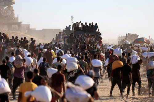 Palestinians carry aid supplies that entered Gaza through Israel, in Beit Lahia in the northern Gaza Strip, July 30, 2025. REUTERS/Dawoud Abu Alkas TPX IMAGES OF THE DAY