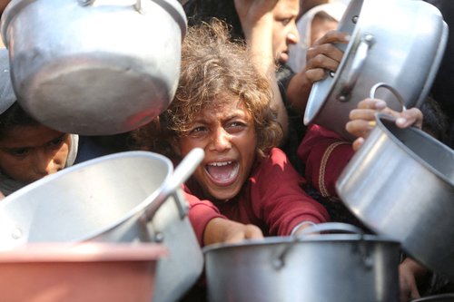 FILE PHOTO: A child reacts surrounded by pots as Palestinians wait to receive food from a charity kitchen in Khan Younis, southern Gaza Strip, August 21, 2025. REUTERS/Hatem Khaled/File Photo