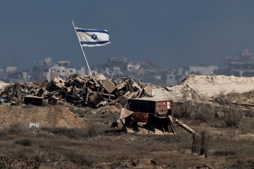 An Israeli flag flutters in Gaza, as seen from the Israeli side of the border with Gaza