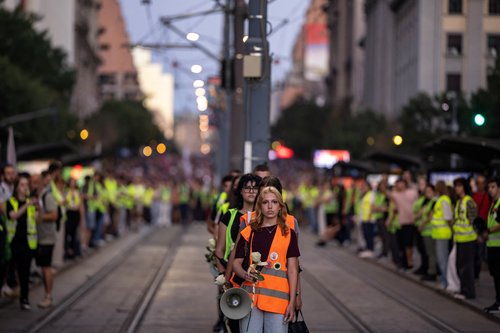 Students hold flowers to commemorate the 16 victims