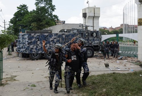 A riot police officer is taken to the hospital after being injured during