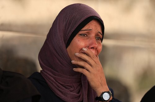 A mourner reacts during the funeral of Palestinians killed in overnight Israeli strikes