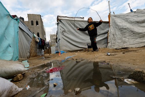 A child plays with a skipping rope as displaced Palestinians shelter in a tent camp in Deir al-Balah, central Gaza Strip, January 19, 2026. REUTERS/Mahmoud Issa TPX IMAGES OF THE DAY