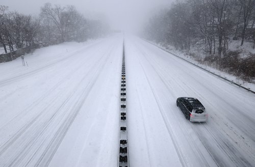 A single car travels north on the snow-covered New York State Thruway I-287 as a major winter storm spreads across a large swath of the United States, in Nyack, New York, U.S.