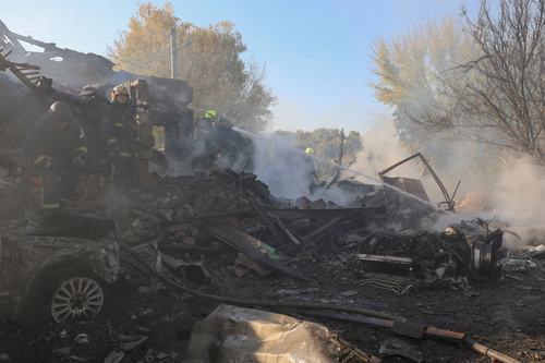 Firefighters work at the site of private houses hit by a Russian air strike