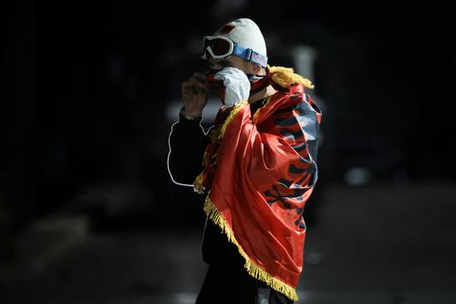 A protester is covered with Albanian national flag during an anti-government protests, in Tirana, Albania, October 25, 2026. REUTERS/Valdrin Xhemaj
