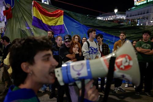 A man uses a megaphone as people gather at the protest camp at Puerta del Sol square following the death of Maricarmen Abascal