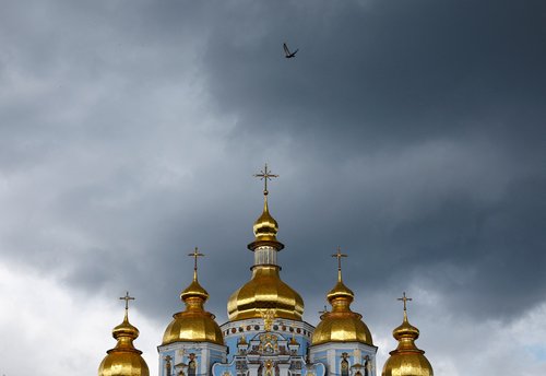 Pigeon flies over the St. Michael's Golden-Domed Cathedral in Kyiv