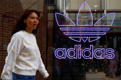 A woman walks past an Adidas store in Beijing