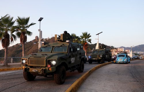 Mexican soldiers patrol in armored vehicles in Acapulco after authorities reinforced security following roadblocks and arson attacks carried out by organised crime in several states, in the aftermath of a military operation in which a government source sa
