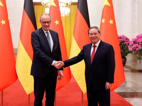 China's Premier Li Qiang and Germany's Chancellor Friedrich Merz shake hands at the Great Hall of the People in Beijing, China