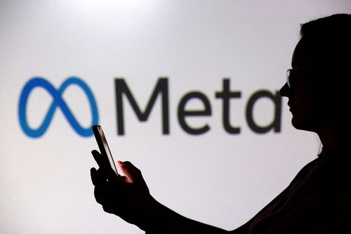 FILE PHOTO: A teenager poses for a photo while holding a smartphone in front of a Meta logo in this illustration taken September 11, 2025. REUTERS/Dado Ruvic/Illustration//File Photo