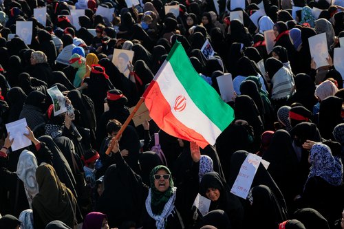 A Shiite Muslim woman chants slogans and holds an Iranian flag as she, along with others, participates in a protest, following the killing of Iran's Supreme Leader Ayatollah Ali Khamenei in U.S. and Israeli strikes on Saturday