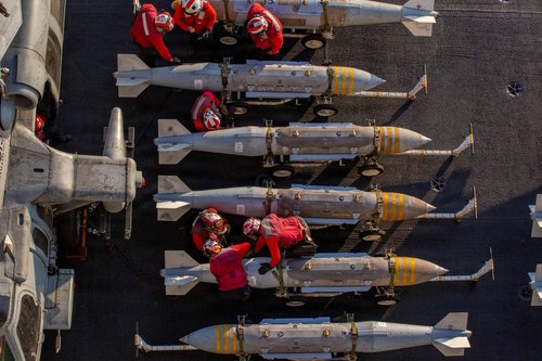 U.S. Navy sailors prepare to stage ordnance on the flight deck of the Nimitz