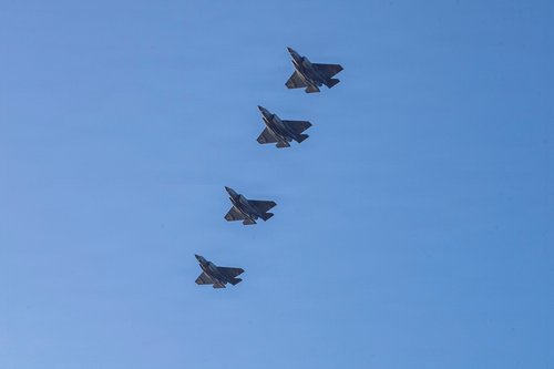 U.S. Navy aircraft fly over the flight deck of the Nimitz-class aircraft carrier