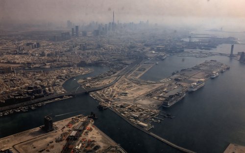 A view from inside a stained window of an airplane shows Dubai