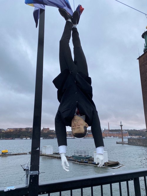 Puppet of Turkish President Erdogan is hung by its feet during demonstration in Stockholm