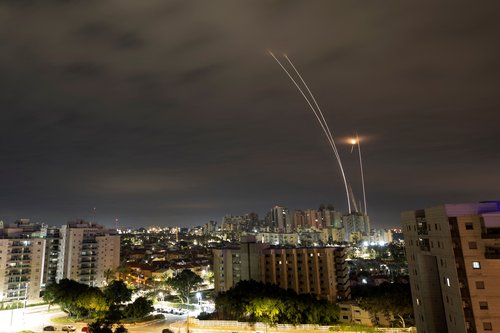 A trail of smoke is seen as rockets from Gaza are intercepted in the early morning, as seen from Ashkelon
