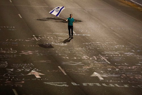 Israeli protestors attend a right-wing demonstration in support of Israel's nationalist coalition government and its judicial overhaul, in Tel Aviv