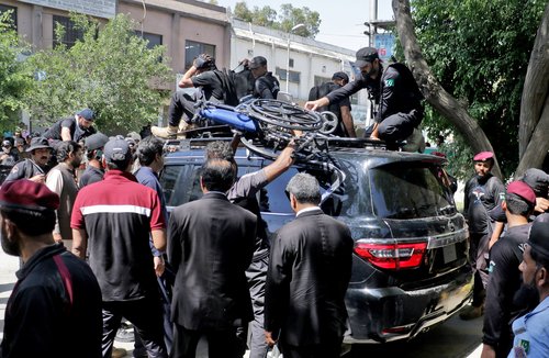 Pakistan security forces guard a vehicle carrying former Prime Minister Imran Khan after his arrest at a court in Islamabad
