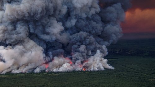 Smoke billows upwards from a planned ignition by firefighters tackling the Donnie Creek Complex wildfire south of Fort Nelson