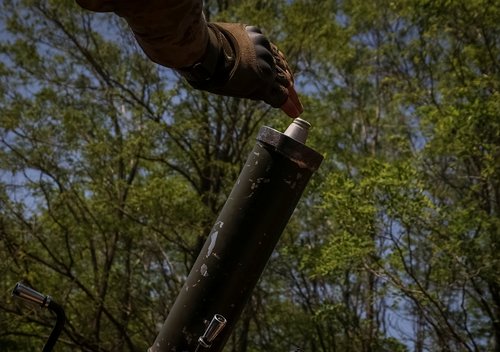 A Ukrainian service member prepares to fire a mortar at a front line near the city of Bakhmut