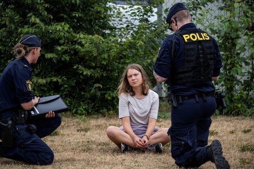 FILE PHOTO: Police talk to Greta Thunberg as they move climate activists who are blocking the entrance to Oljehamnen in Malmo