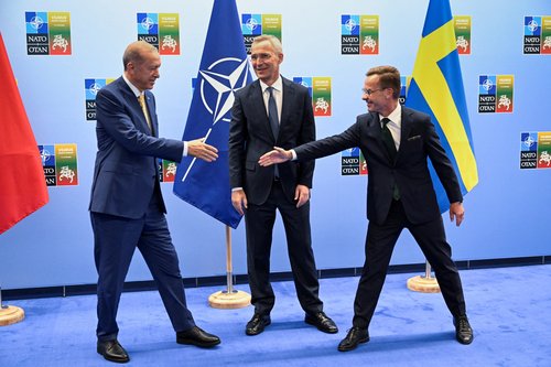 Turkish President Erdogan and Swedish Prime Minister Kristersson shake hands next to NATO Secretary-General Stoltenberg prior to their meeting, in Vilnius