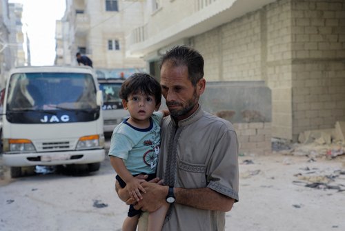 Syrian father and quake survivor, Jomaa Biazid, holds his son Ibrahim in al-Dana town