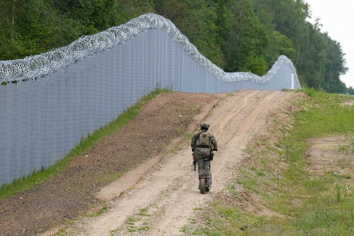 Latvian special unit Border Guard officer patrols along the fence at Latvia-Belarus border near Robeznieki