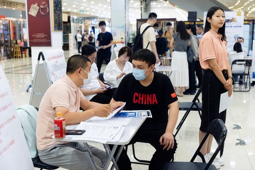 FILE PHOTO: People attend a job fair in a mall in Beijing