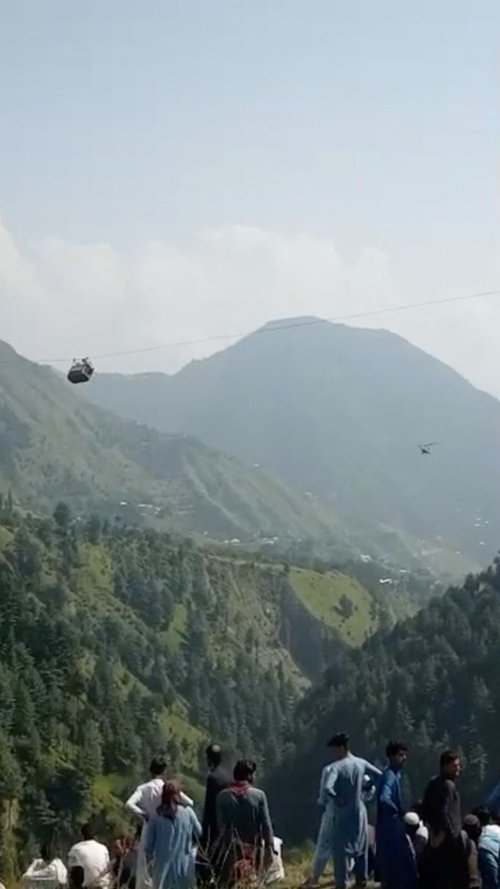 A view shows a helicopter carrying rescue operation next to the cable car with students stranded mid-air in Battagram