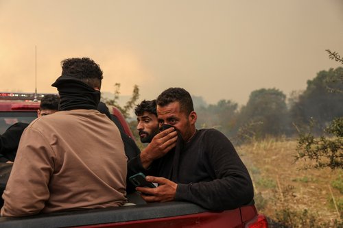 Migrants moved to safety as a wildfire still rages in the region of Evros