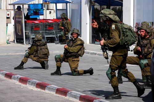 Israeli soldiers work to secure residential areas following a mass-infiltration by Hamas gunmen from the Gaza Strip, in Sderot