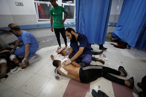 People are assisted at Shifa Hospital after hundreds of Palestinians were killed in a blast at Al-Ahli hospital in Gaza that Israeli and Palestinian officials blamed on each other