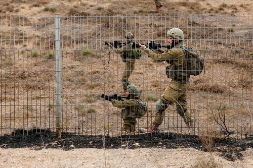 FILE PHOTO: Israeli soldiers scan an area while sirens sound as rockets from Gaza are launched towards Israel,, near Sderot, southern Israel