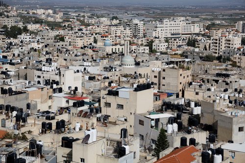 Palestinians check the damage at a mosque which was hit in an Israeli air strike, in Jenin